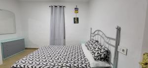 a bedroom with a bed with black and white sheets at Costa de Granada Calle peatonal in Salobreña