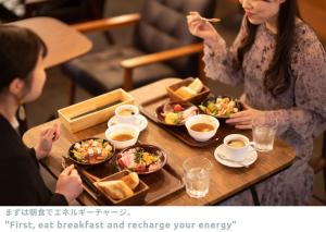 two women sitting at a table eating food at LINNAS Kanazawa in Kanazawa