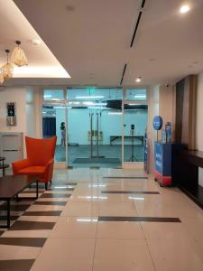 an empty lobby with a red chair in a building at 2BR Pioneer Woodlands SM LIGHT by AwayHome Rentals in Manila