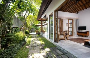 einen Garten vor einem Haus mit einem Weg in der Unterkunft Villa Kayu Lama in Ubud