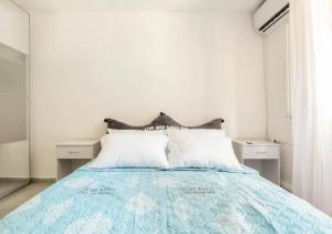 1 dormitorio con 1 cama con 2 almohadas blancas en Central 1BR Oasis, Fast Fiber WiFi, Free Parking, Free Netflix with Shelter, en Haifa