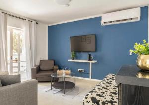 una sala de estar con una pared azul en Central 1BR Oasis, Fast Fiber WiFi, Free Parking, Free Netflix with Shelter, en Haifa