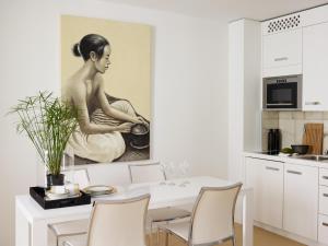 a dining room with a painting of a woman holding a pot at VISIONAPARTMENTS Otto-Braun-Strasse - contactless check-in in Berlin