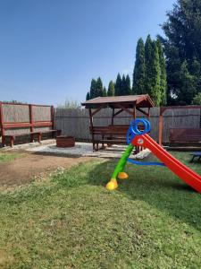 a swing set in a yard with a bench at Zsuzsanna vendégház in Mezőkövesd
