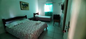 a bedroom with a bed and a chair in a room at Pousada Casa da Lucinha in Fortaleza