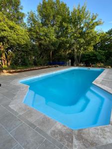 une piscine bleue avec des arbres en arrière-plan dans l'établissement La Girondine, à Saint-Philippe-dʼAiguille