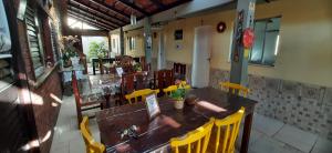 a restaurant with a wooden table and yellow chairs at Pousada Casa da Lucinha in Fortaleza