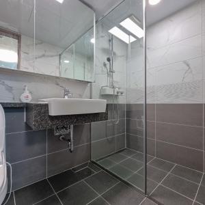 a bathroom with a sink and a glass shower at Humphreys 2 min Vintage Korean Room in Pyeongtaek