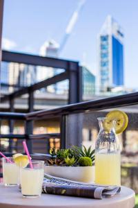 a table with a bottle of lemonade and two glasses at Heart of the City 504 in Perth