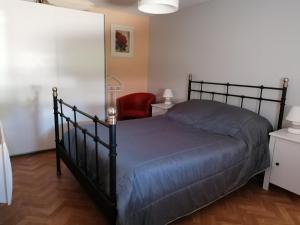 a bedroom with a black bed and a red chair at Charmante longère 80m² à 6km des Thermes - Terrasse, Jardin, Barbecue, Animaux acceptés - FR-1-541-31 in La Roche-Posay +2 photos