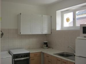 a kitchen with white cabinets and a sink and a window at Maison Coussay-les-Bois, 3 pièces, 4 personnes - FR-1-541-38 in Coussay-les-Bois
