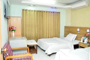 a hotel room with two beds and a chair at Hotel Aero link Ltd in Dhaka