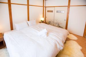 a large white bed with two towels on it at RUSUTSU HOLIDAY CHALET / Vacation STAY 3822 in Makkari