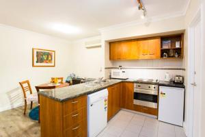 a kitchen with wooden cabinets and a counter top at Perth City Living 105 in Perth