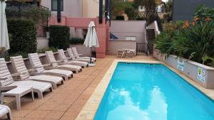 uma piscina com cadeiras e um guarda-sol ao lado de um edifício em Perth City Living 105 em Perth