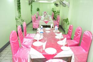 uma sala de jantar cor-de-rosa com uma mesa e cadeiras cor-de-rosa em Hotel Aero link Ltd em Daca