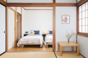 een slaapkamer met 2 bedden en een spiegel bij Bell-Rental Villa Engawa House in Fujikawaguchiko