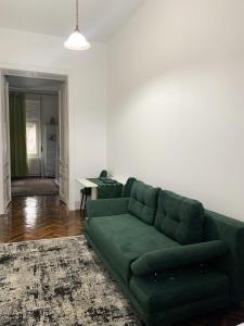 un soggiorno con divano verde e tavolo di Diana’s Apartment a Arad