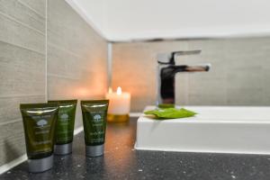 a bathroom counter with three candles and a sink at Long Eaton Modern 4bed House in Long Eaton