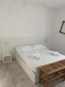 a white bed with two towels on top of it at fuORIOrbita in Orio al Serio