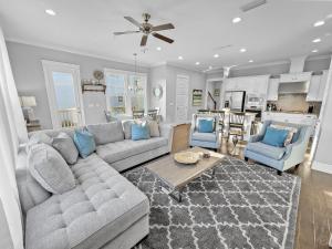 a living room with a couch and chairs and a kitchen at Floridays Home in Blue Mountain Beach