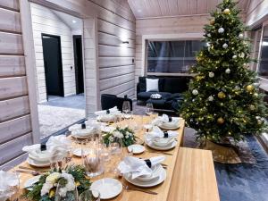 a table with a christmas tree in a room at Santa's Luxury Boutique Villa - Santa Claus Village in Rovaniemi