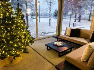 Santa's Luxury Boutique Villa - Santa Claus Village في روفانييمي: غرفة معيشة مع شجرة عيد الميلاد وأريكة