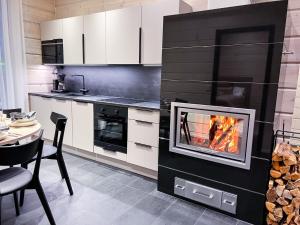 a kitchen with a fireplace in the middle at Santa's Luxury Boutique Villa - Santa Claus Village in Rovaniemi