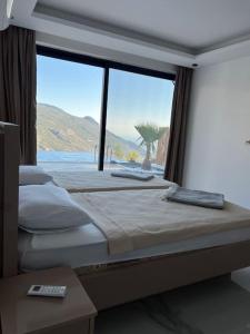 a bedroom with two beds and a large window at Villa Vilara „Luxus Villa mit Traumaussicht“ in Kas