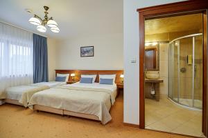 pokój hotelowy z dwoma łóżkami i prysznicem w obiekcie Hotel Burkaty w mieście Białka Tatrzanska