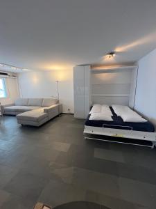 - une grande chambre avec un lit et un canapé dans l'établissement SmartHome Top of the World, à Saint-Moritz