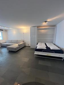 um quarto grande com uma cama e um sofá em SmartHome Top of the World em St. Moritz