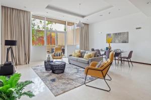 un soggiorno con divano, sedie e tavolo di Tiara Beach Residences, Palm Jumeirah Dubai - Mint Stay a Dubai