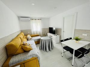 a living room with a yellow couch and a table at AITA CASA BARBATE in Barbate