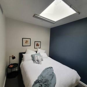 a bedroom with a white bed with a blue wall at Melbourne Luxury Penthouse in prime location in Melbourne