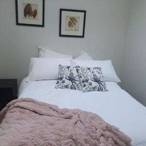 Una cama blanca con manta y almohadas. en Melbourne Luxury Penthouse in prime location, en Melbourne