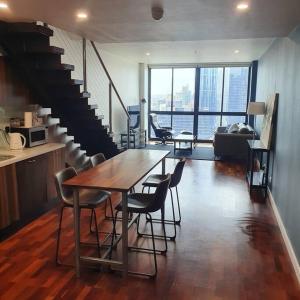 une salle à manger avec une table, des chaises et un escalier dans l'établissement Melbourne Luxury Penthouse in prime location, à Melbourne