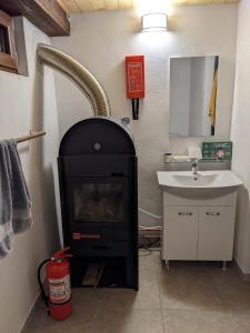a bathroom with a fireplace next to a sink at Open View Place The A Frame in Scăricica
