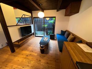 a living room with a blue couch and a tv at Rinn Shiki Juraku in Kyoto