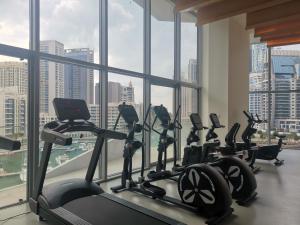 un gimnasio con varias máquinas de correr en una gran ventana en Vacay Lettings - Waterfront Luxury home with full Marina view, en Dubái