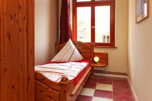 a wooden bed in a room with a window at Villa Maria Wohnung 05 in Ostseebad Koserow
