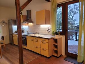 a kitchen with yellow cabinets and a sink and a window at Gästewohnung " Am Harsdorf " in Magdeburg