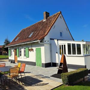 ポペリンゲにある't Haringehuysの白い家(緑のドア、テーブル、椅子付)