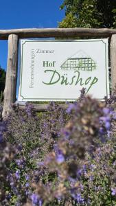 un signo de bebida caliente con flores púrpuras en Hof Düshop, en Bad Fallingbostel