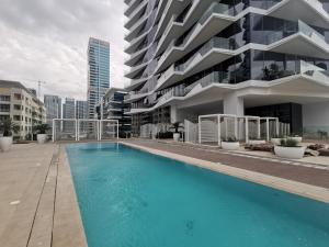 une piscine en face d'un bâtiment dans l'établissement Vacay Lettings - Waterfront Luxury home with full Marina view, à Dubaï