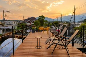 eine Terrasse mit Stühlen und einem Tisch auf einem Boot in der Unterkunft CAMP＆COTTAGE THE DOOR in Fujikawaguchiko