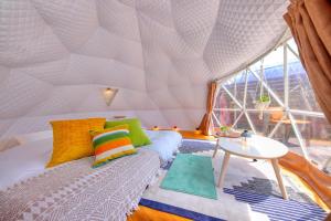 una camera con letto e tavolo in tenda di CAMP＆COTTAGE THE DOOR a Fujikawaguchiko