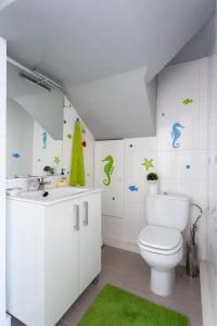 baño con aseo blanco y alfombra verde en Home2Book Charming Sea Front House en El Escobonal