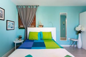 ein Schlafzimmer mit einem farbenfrohen Bett und einem Fenster in der Unterkunft Home2Book Charming Sea Front House in El Escobonal