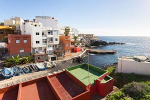 un edificio con una mesa de ping pong junto al océano en Home2Book Charming Sea Front House en El Escobonal